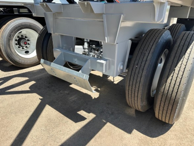 Lightweight bottom-dump trailer hitch area showing dual rear axles, support frame, and landing gear; no legible text visible on components.