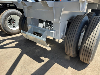 Bottom-dump trailer undercarriage showing dual rear tires and folding tailgate in a light-weight design.