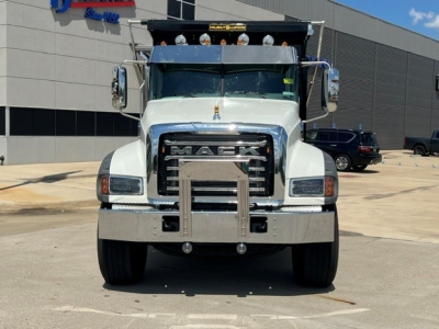 Front view of a white 2027 Mack GR104F dump truck showing large chrome grille, bumper guard, and 'MACK' emblem with hood lights.