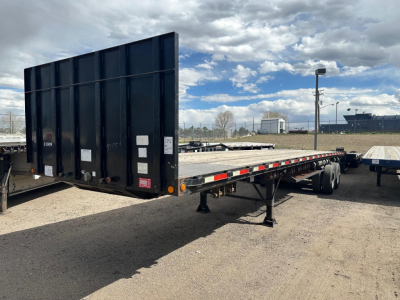 Trailer rear and side view showing 38' Clark flatbed trailer with wood deck and forklift kit, black steel sides, dual rear axles, undercarriage, and landing legs.