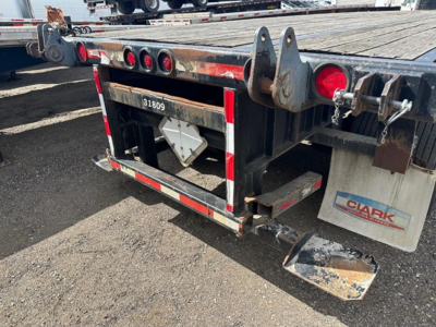 Trailer rear view showing flatbed with Wood deck and Clark tag, tail lights, bumper, and mud flaps.