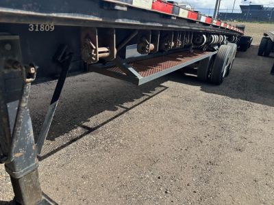 Trailer undercarriage showing structural beams and wheels; visible numbers '31809' on frame and a metal checker plate step.