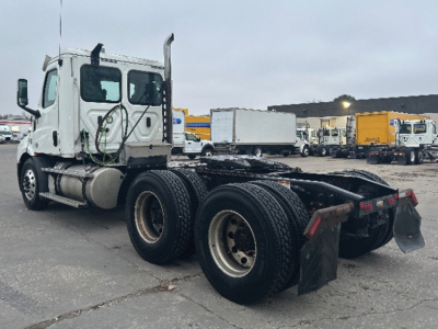 Freightliner Cascadia 116 tractor with fifth wheel, dual rear axles, and white sleeper cab from side view.