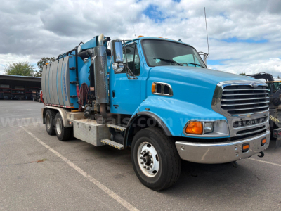 2007 Sterling LT9500 vacuum truck side view showing blue cab and front grille, waste tank, hoses, and equipment rack.