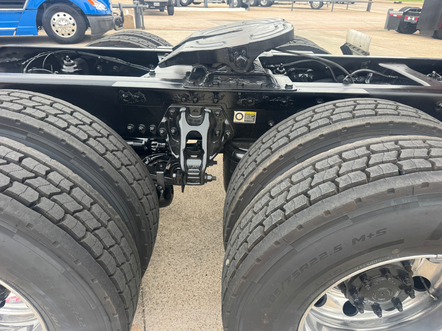 Kenworth T680 chassis view showing dual rear axles and suspension components with tires and frame.