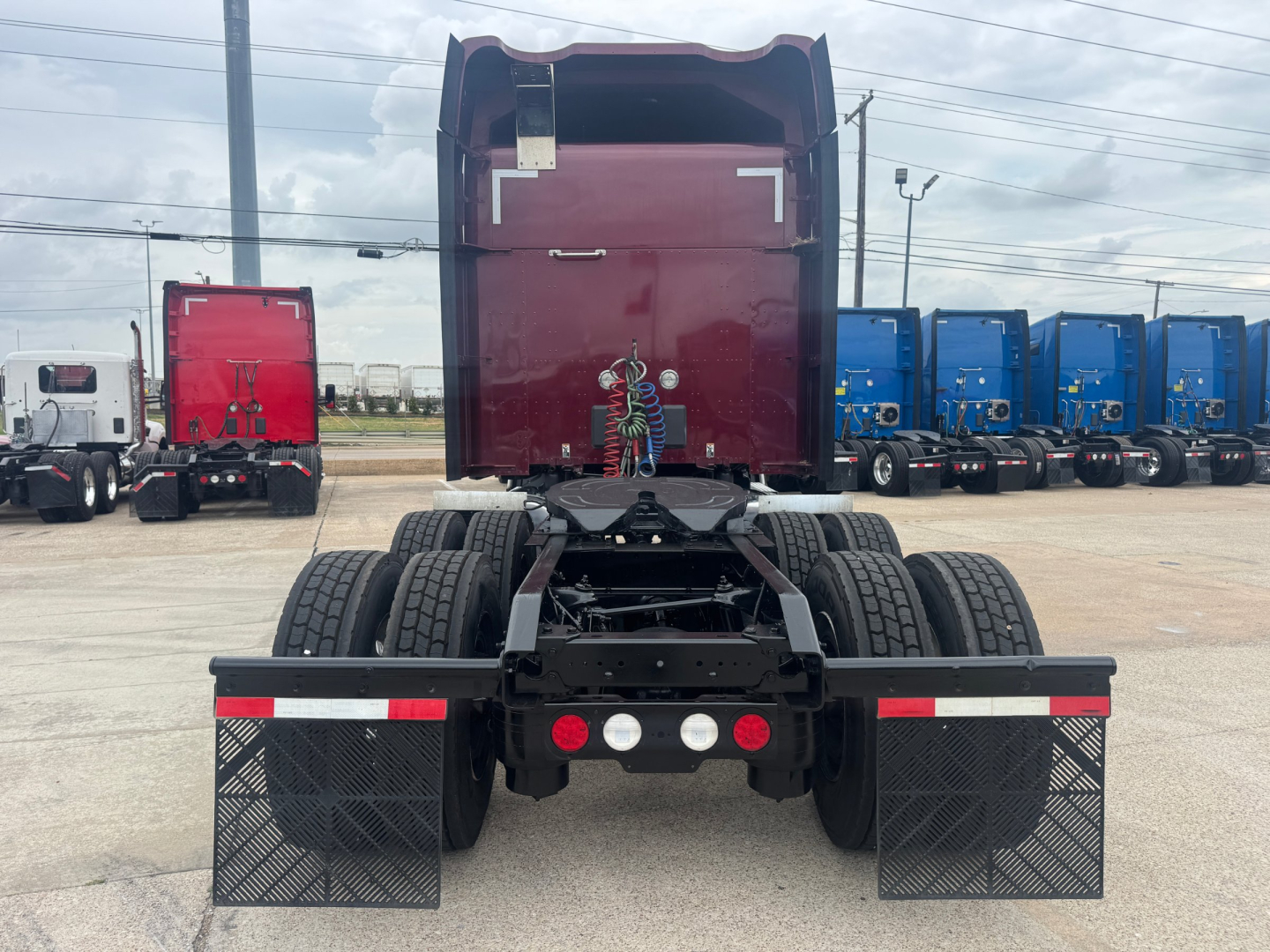 Kenworth T680 tractor rear view showing dual rear axles and mudflaps with textured pattern.