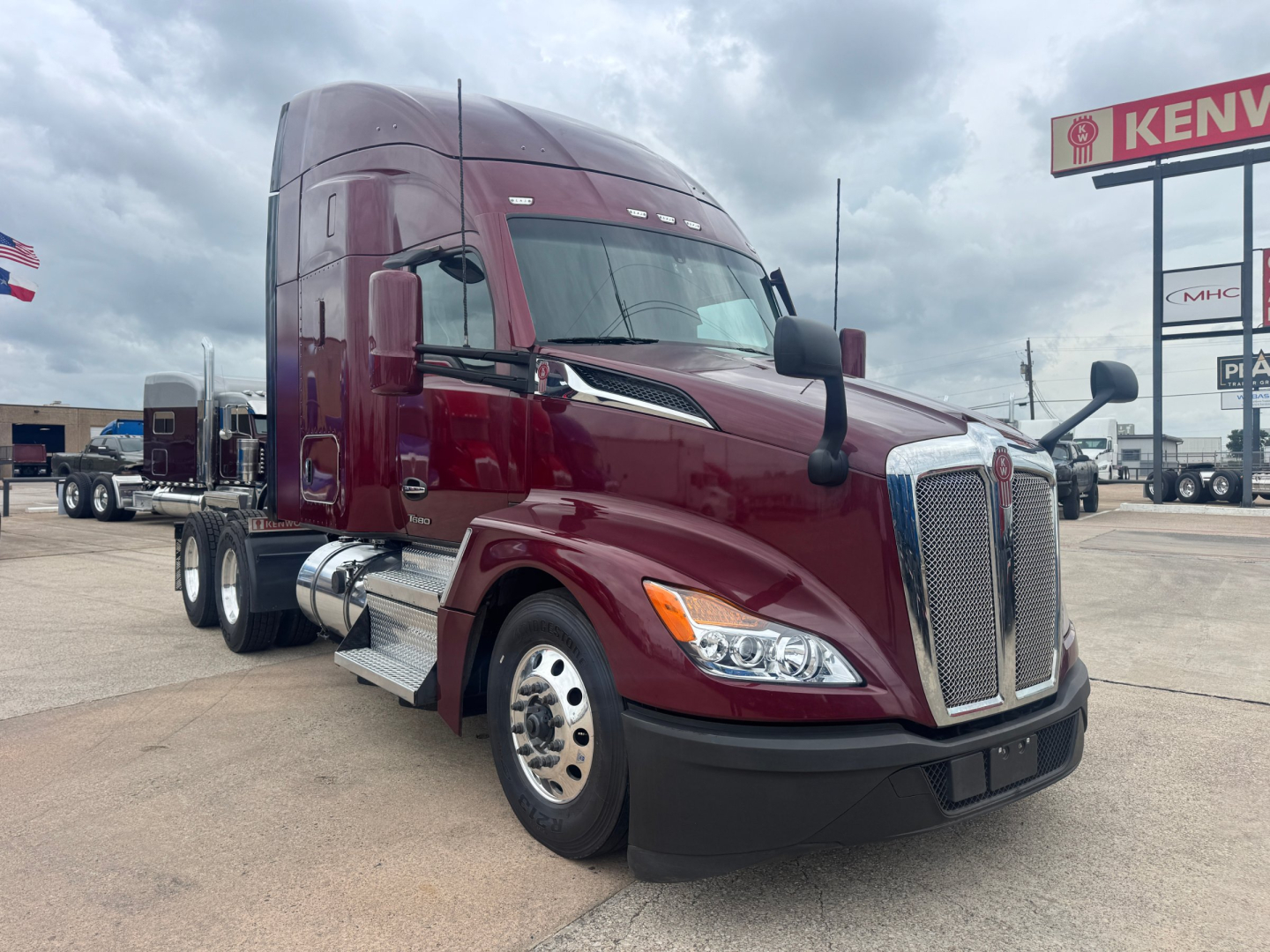 Kenworth T680 truck in maroon showing front grille and cab with chrome mirrors.