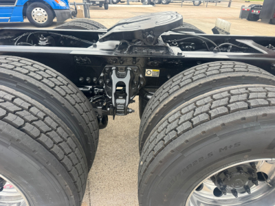 Kenworth T680 chassis view showing dual rear axles and suspension components with tires and frame.