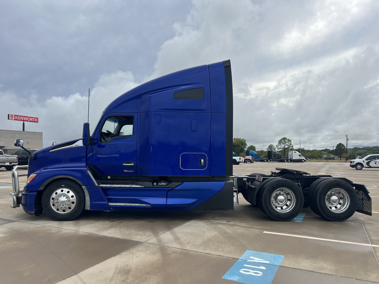 Kenworth T680 conventional sleeper truck in blue, side profile view, with extended cab and rear dual axles.
