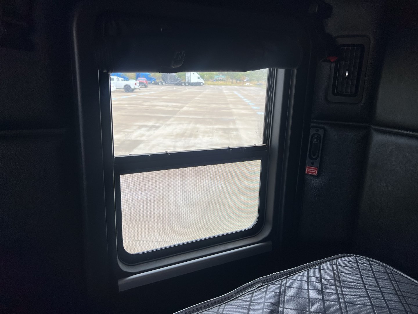 Kenworth T680 truck cab interior showing side window and interior panel; no engine or label text visible.