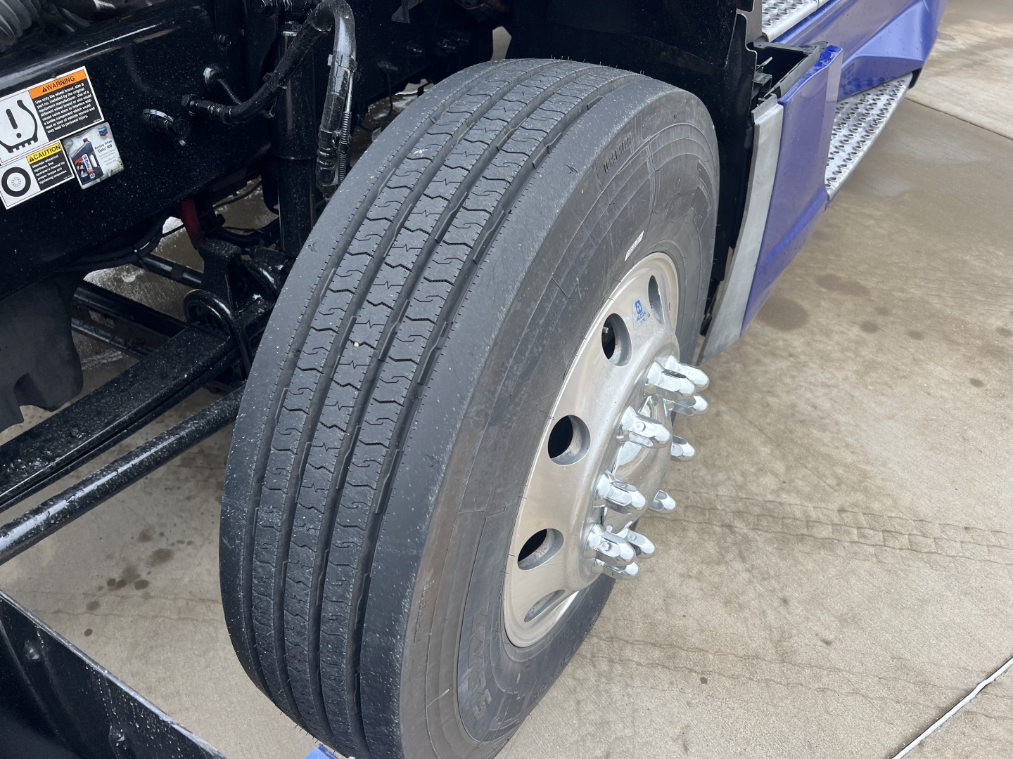 Truck wheel and dual rear tires of a Kenworth T680 with visible tire treads and wheel studs.