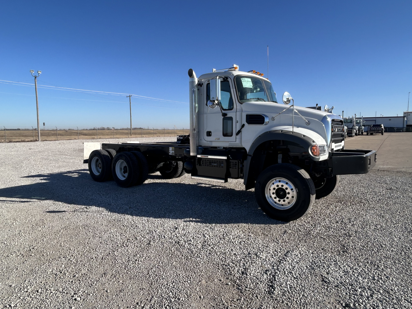 Mack GR64F heavy-duty truck cab and chassis side view with white cab and extended wheelbase.