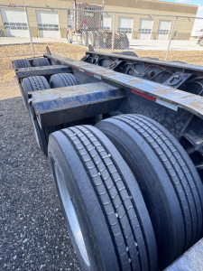 Trailer wheelset and frame showing dual rear axles with tires and metal framework