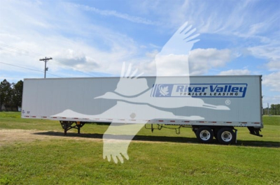 Trailer side view showing River Valley Trailers logo on white utility trailer 4000D-X with dual axles in an open field.