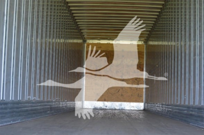 Trailer interior showing corrugated metal walls and wooden floor with a watermark birds logo overlay.