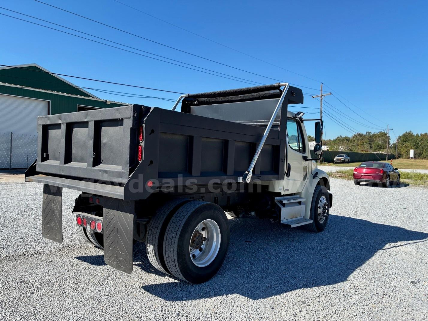 2009 Freightliner M2 106 dump truck rear and side view showing dump bed, taillights, and wheel, with VIN and stock info in listing context.