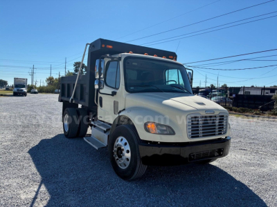 2009 Freightliner M2 106 dump truck front-left view showing cab, grille, headlights, and dump bed with VIN 1FVACXDT79HAH0881 on listing image.