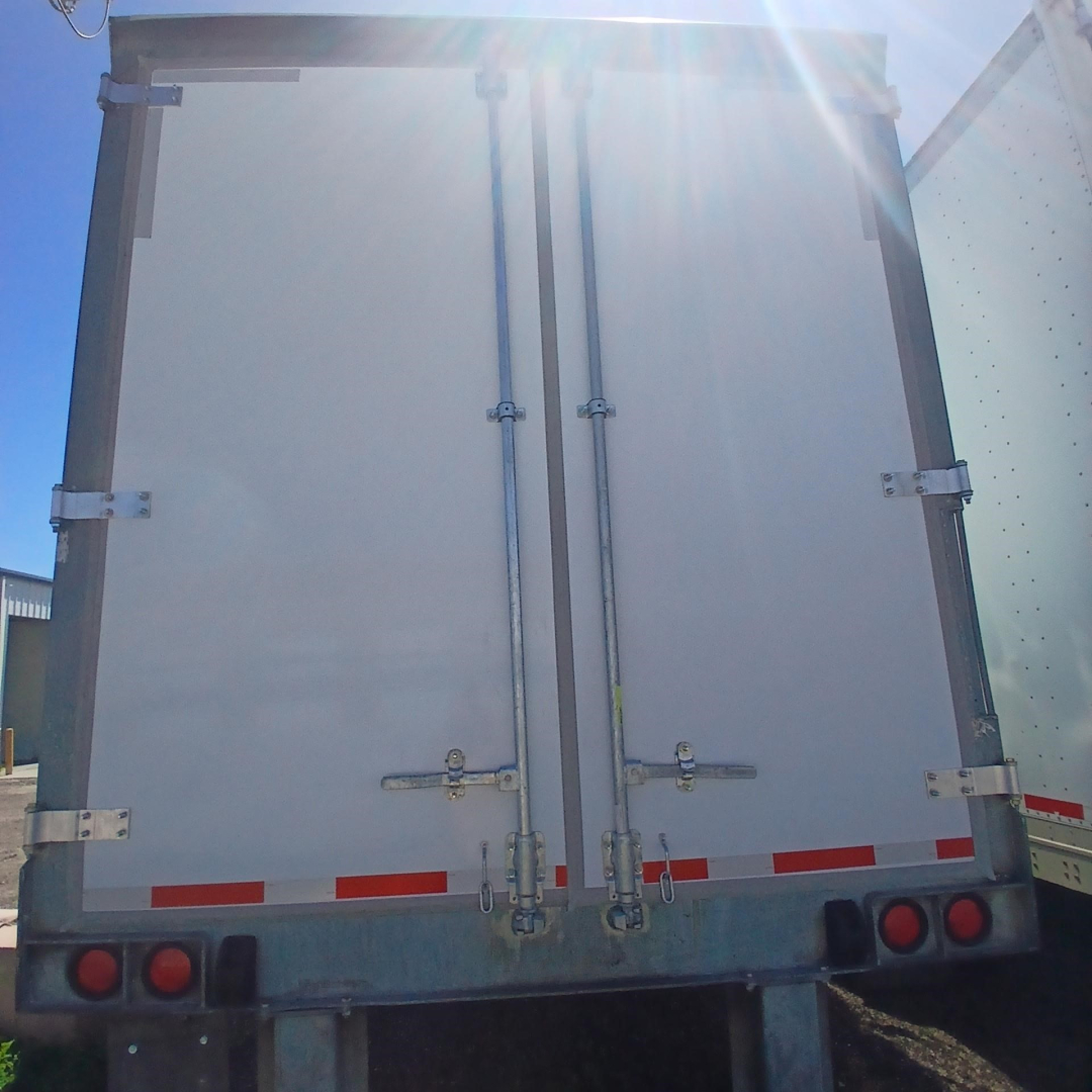 Rear view of a Hyundai air ride dry van trailer with double vertical cargo doors, metal hinges, latches, and red reflector tape along the lower rear edge.