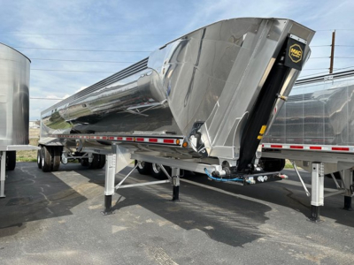 Dump trailer showing shiny polished steel MAC Macsimiser with front toolbox and landing gear in a raised position.