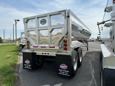 Mac Macsimiser dump trailer rear view showing polished metal, dual rear doors, red and white reflective tape, and dual-tandem wheels.