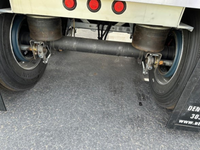 Rear view of a Mac Macsimiser trailer showing the suspension axle, dual tires, and undercarriage components.