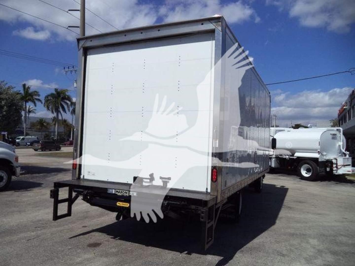 Isuzu NPR HD box truck rear view showing plain white cargo box with no windows; rear bumper and hitch visible.