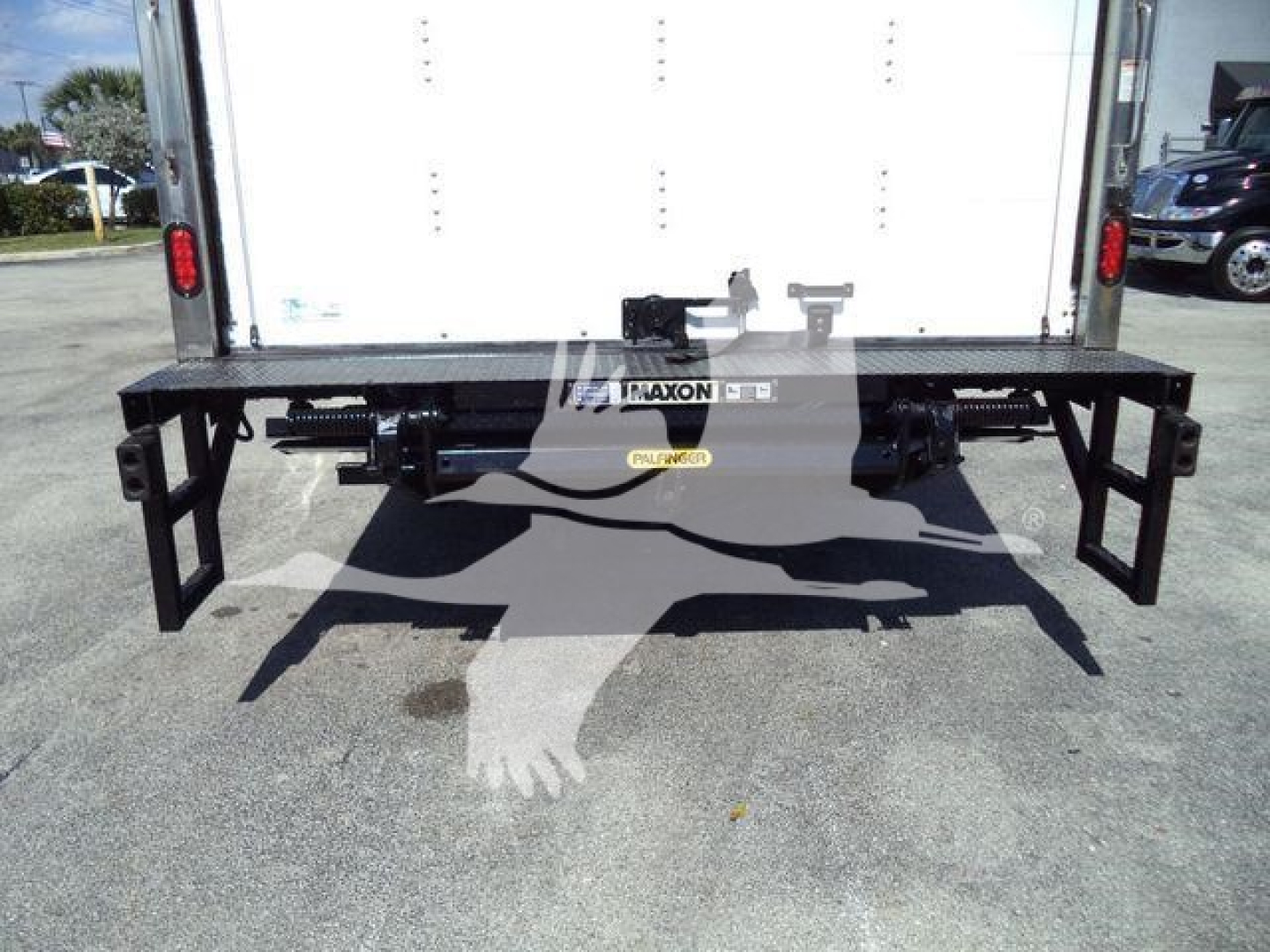Isuzu NPR-HD box truck rear view showing a heavy-duty black steel bumper with pull styles and hitch area.