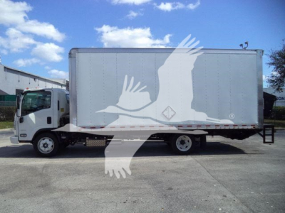 Isuzu NPR-HD box truck side view showing cargo box and cab with VIN plate and stock number in foreground.