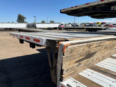 Trailer deck of a Fontaine Cal Legal Drop Deck Rear Slide showing wooden and metal side rails with reflective tape along the edge.