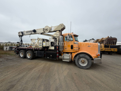 Peterbilt 357 tow truck with large crane arm in orange cab and gray boom, side view