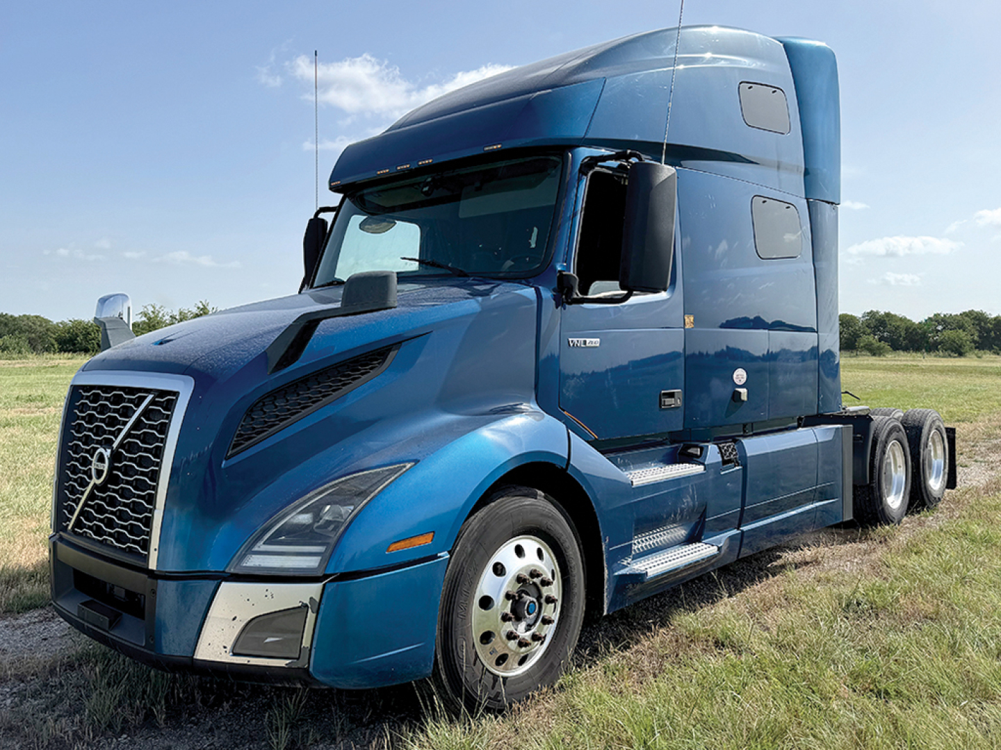 Volvo VNL 760 semi-truck in blue, side view showing sleeper cab and front grille.