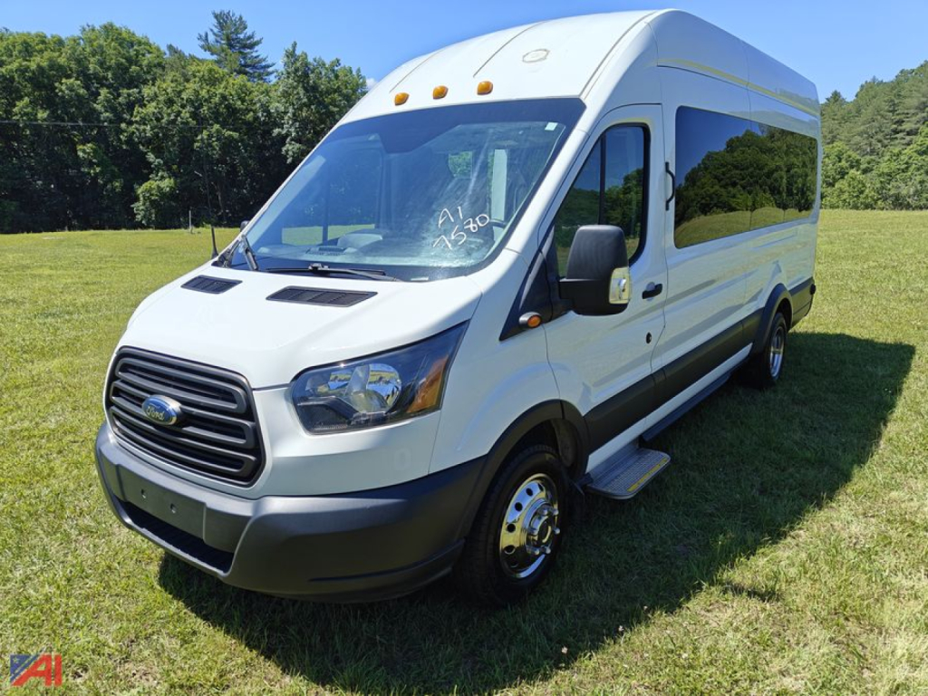 Ford Transit van in a grassy field with wheelchair lift folded along side and front left angle view.