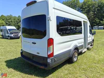 Ford Transit van rear-right view showing wheelchair lift with side window, white body, black bumper, and rear doors.