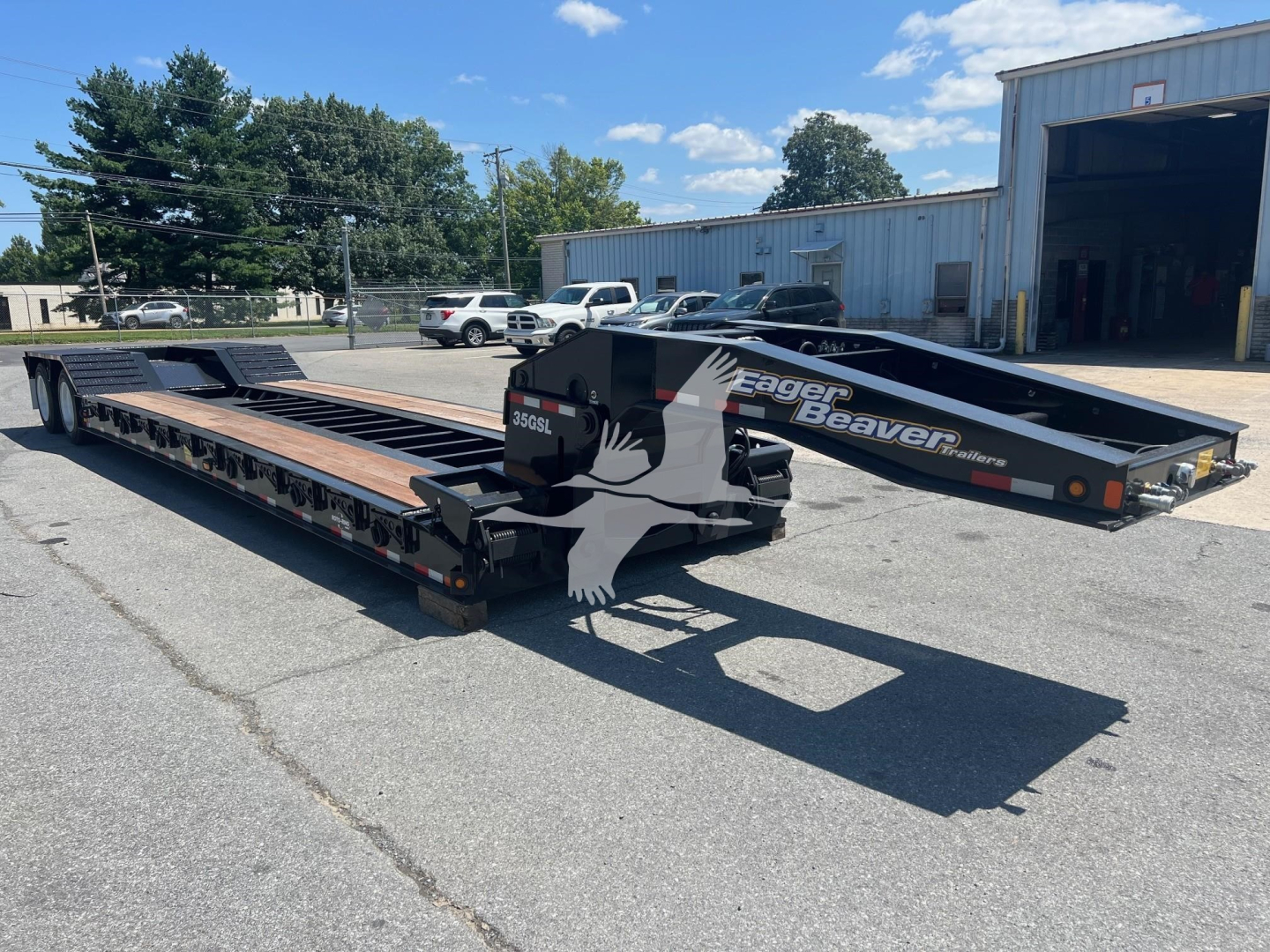 Lowboy trailer showing Eager Beaver 35Gsl-S with black and gray graphics, extended steel deck, and branding along the side.
