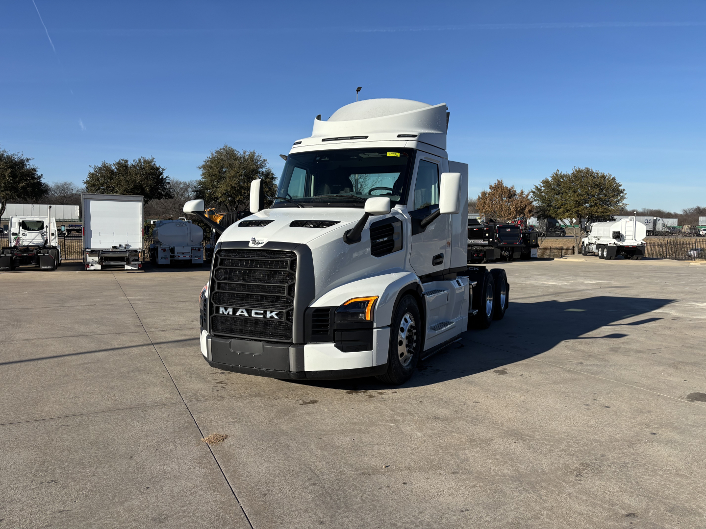 Mack PR64T tractor in white, side view showing front grille with Mack logo and cab mirrors, no trailer attached.