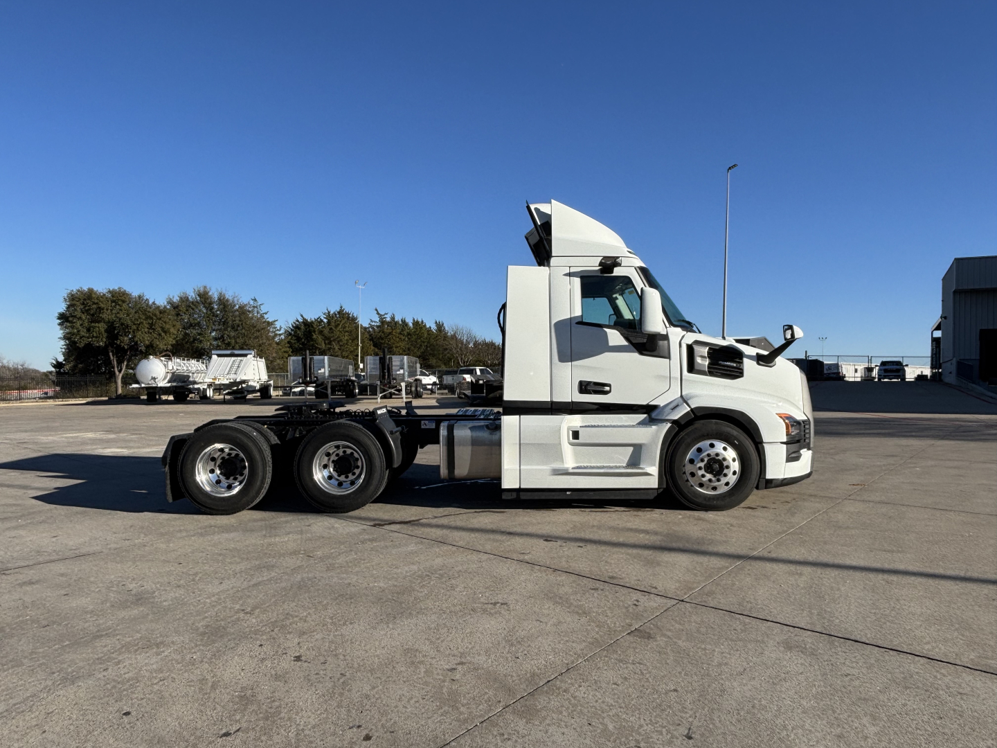 Mack PR64T tractor-trailer truck in profile view, white cab, large sleeper, daycab configuration, 3-axle rear with dual tires, side view showing exhaust stack and aerodynamic hood.