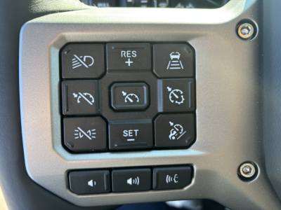 Dashboard control panel with multiple buttons including cruise control icons, lane keeping, and volume controls in a Mack PR64T truck.