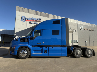 Blue Mack PR64T76H sleeper cab truck on lot in front of dealership