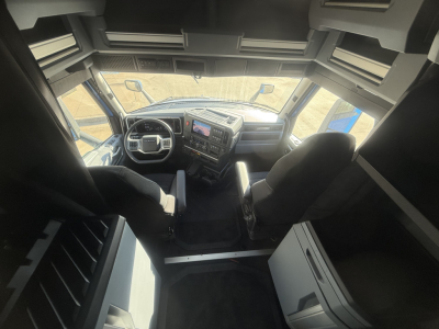 Cab interior of a 2026 Mack PR64T76H tractor showing steering wheel, dashboard, and sleeper area with overhead storage.