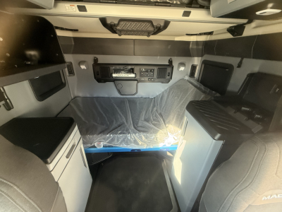  cab interior of a new 2026 Mack PR64T76H sleeper showing dashboard panel and sleeping berth. 