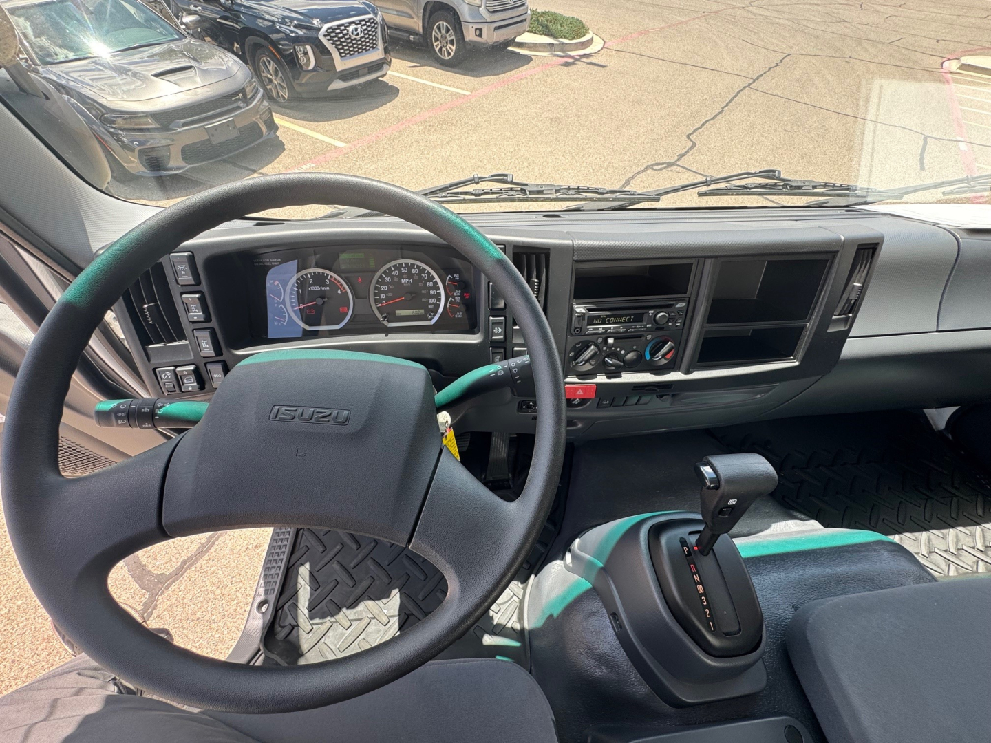 Isuzu FTR interior dashboard and steering wheel view showing gear shifter and instrument cluster.