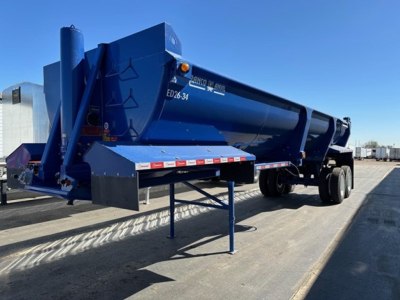 Ranco Ed26-34 dump trailer in blue with side support legs and dual axle setup; ED26-34 text visible on side.