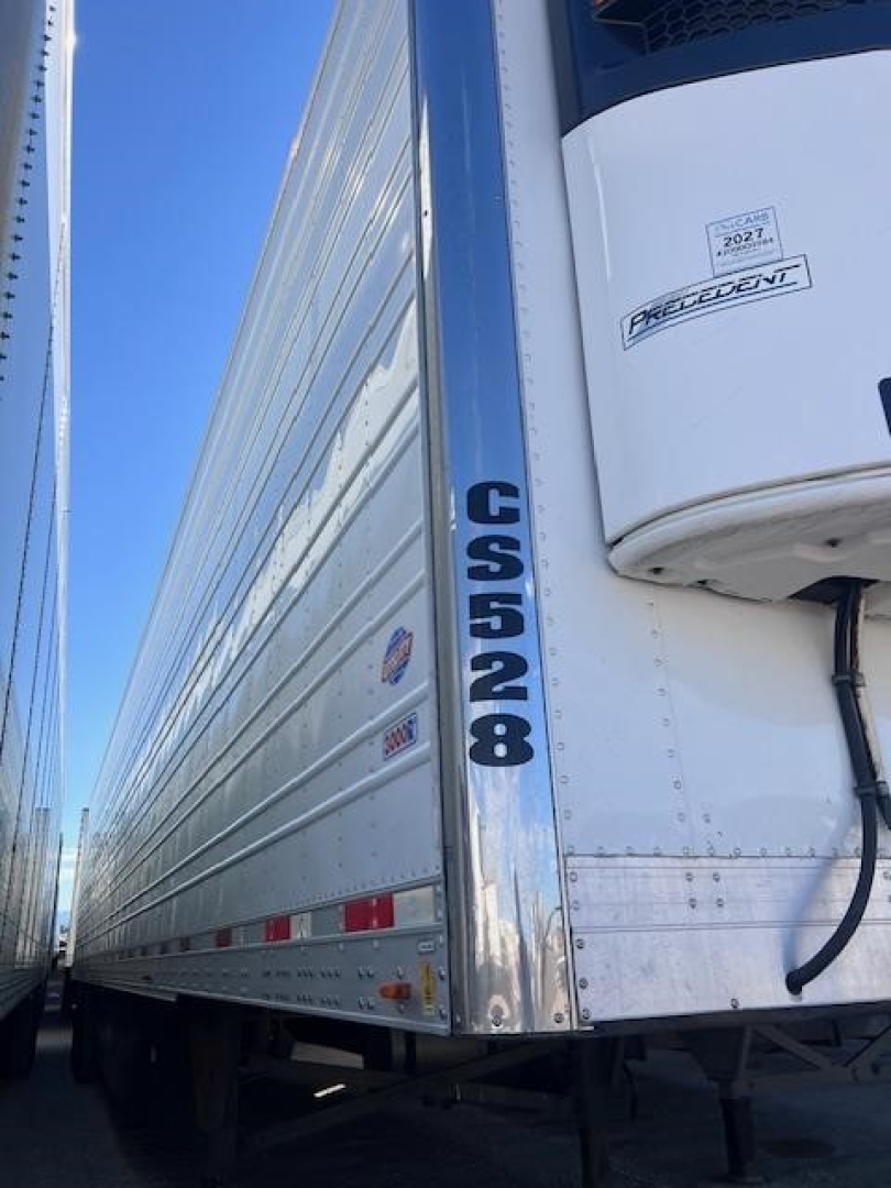 Trailer side of 2022 Utility 3000R reefer showing CS528 placard, Prevost? Precedent refrigeration unit, aluminum trailer with ribbed panels.