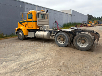 Yellow Peterbilt 367 truck tractor in a lot, side view showing cab, fuel tanks, and rear wheels; no visible text legibly on the image.