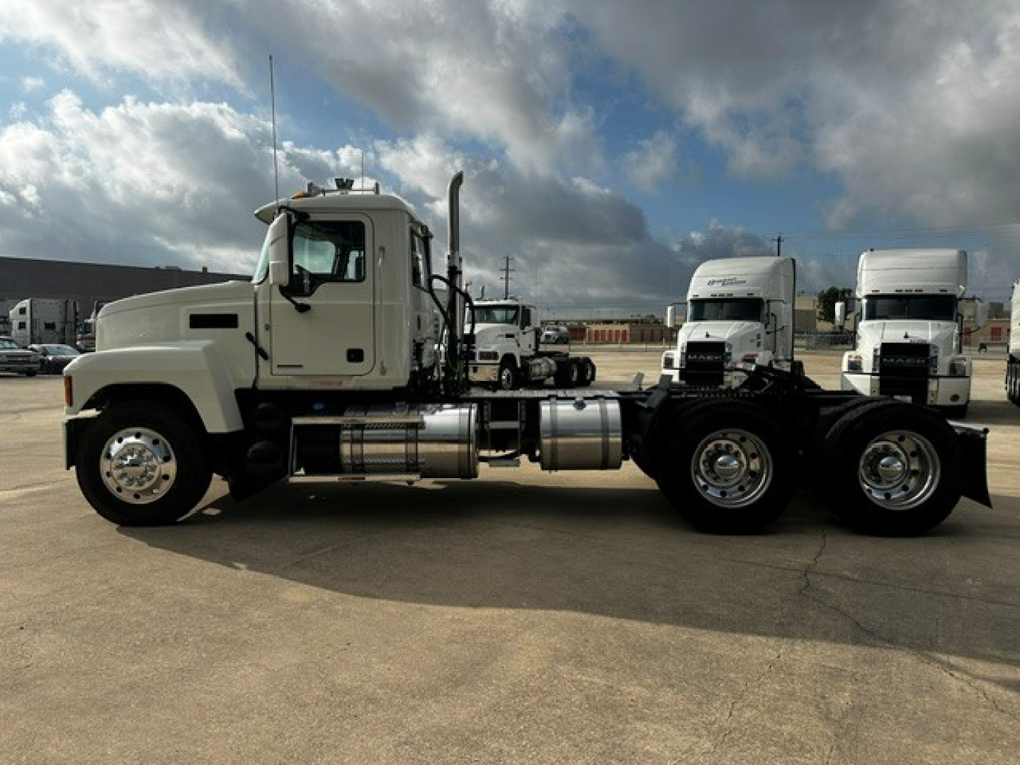 Mack PI64T conventional daycab truck chassis side view showing fuel tanks and dual rear axles.