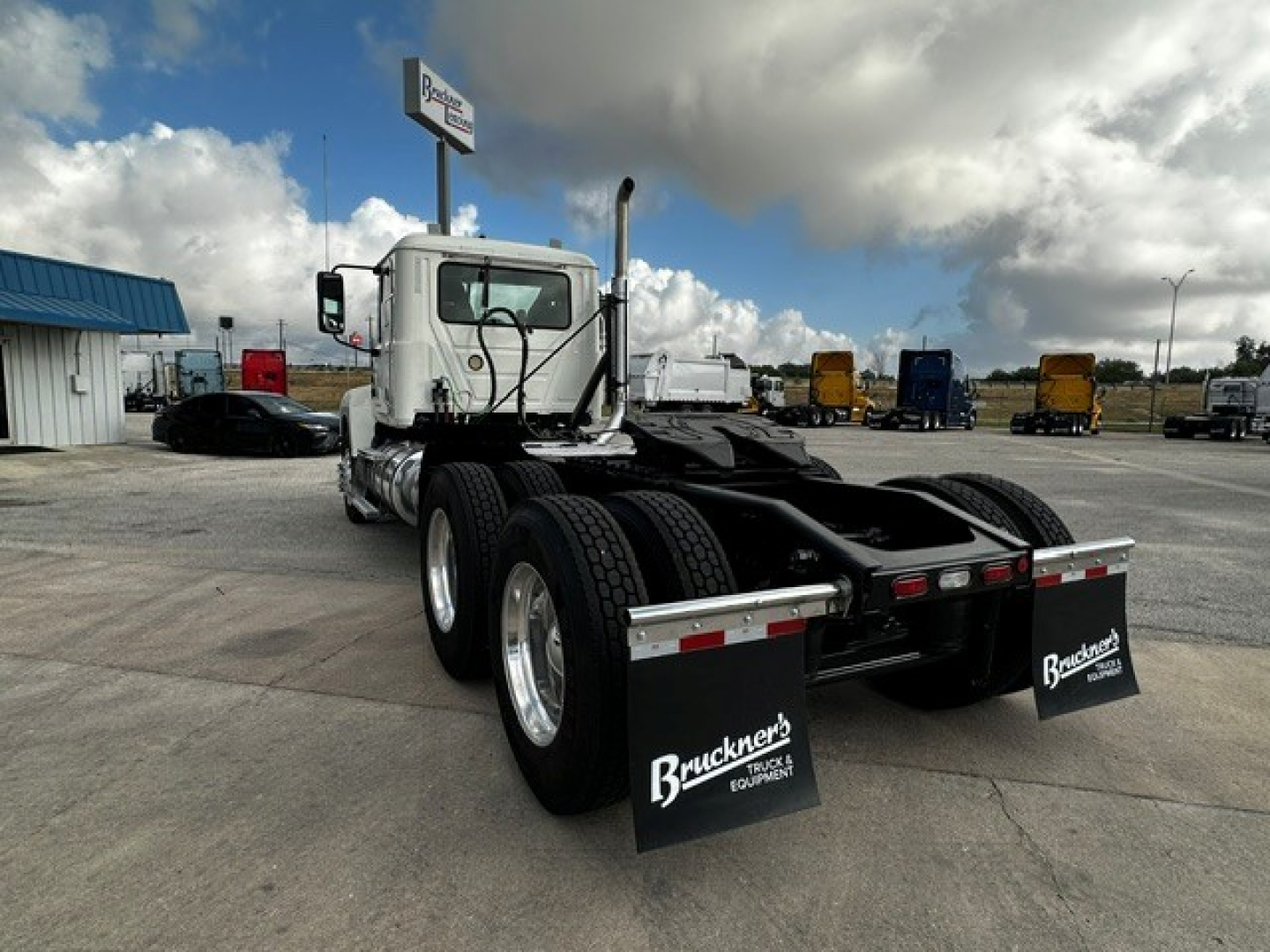 Rear view of a 2019 Mack PI64T daycab tractor showing dual rear axles, mud flaps with 'Bruckner's Equipment' branding, and chassis with fifth-wheel area.