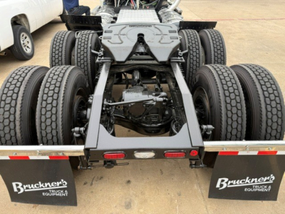 Truck rear chassis of a 2019 Mack PI64T showing dual rear axles and drive line, with mudflaps labeled Bruckner's Truck & Equipment.