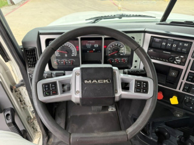Mack PI64T truck interior showing steering wheel, dashboard gauges, and control panel.
