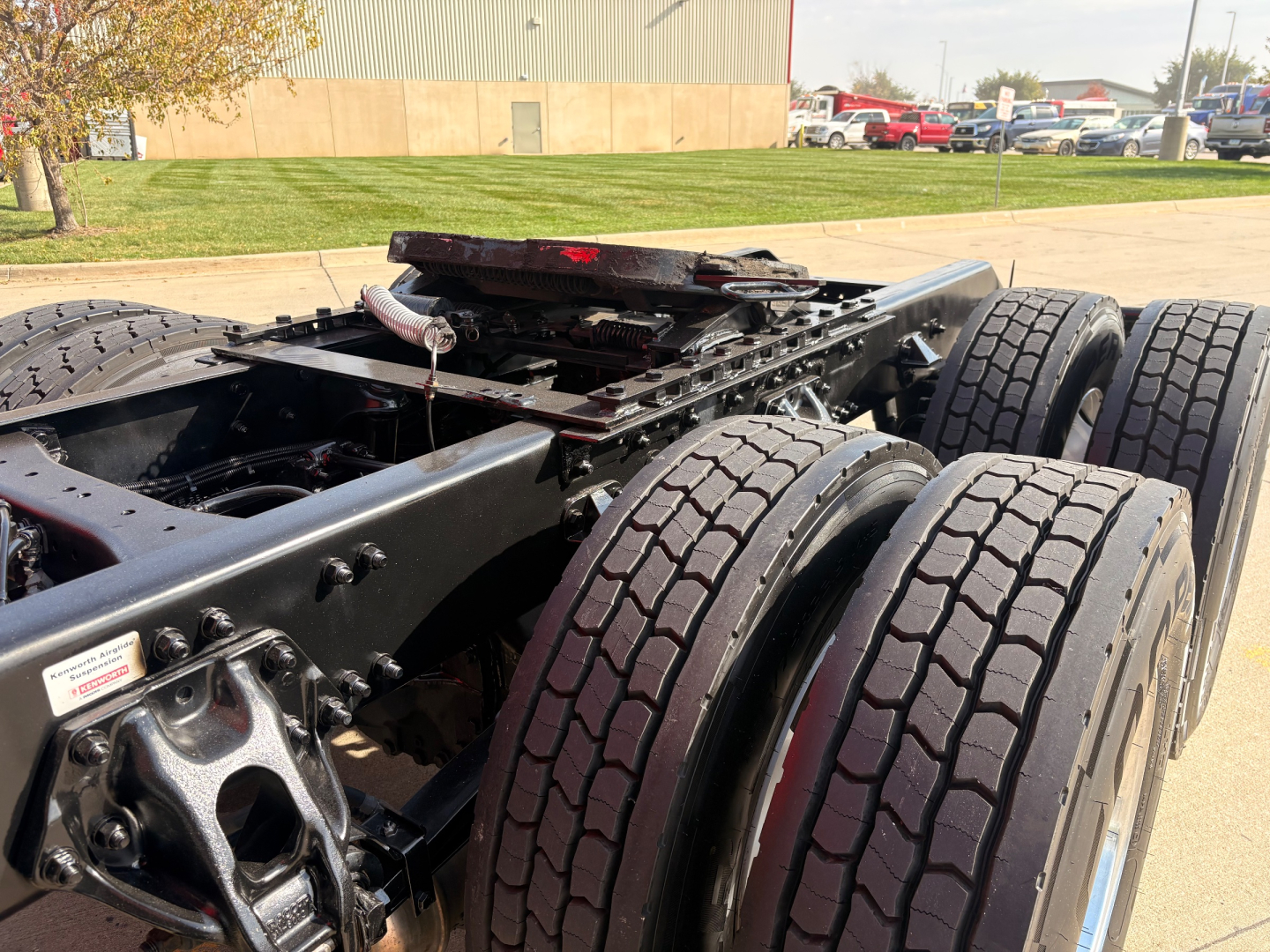 Kenworth T680 chassis and dual rear axles showing heavy-duty tires and frame with fifth wheel, VIN tag area and stock number plate visible.