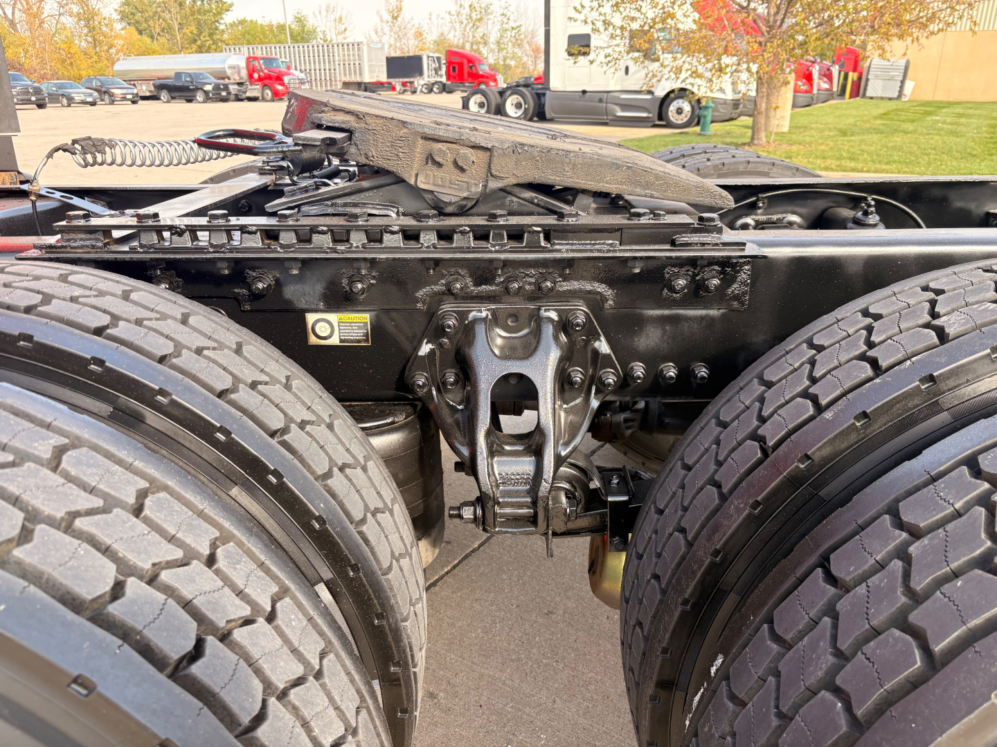 Kenworth T680 chassis viewed from rear deck showing dual rear axles, fifth wheel mount, and frame with suspension components.